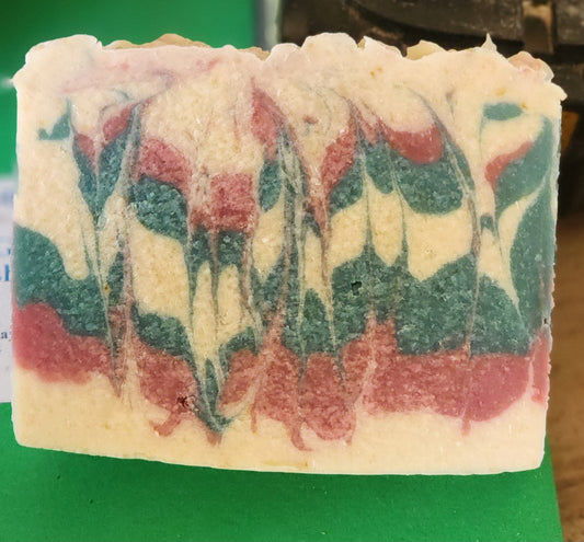 Colorful soap bar with red, green, and white layers on a green background