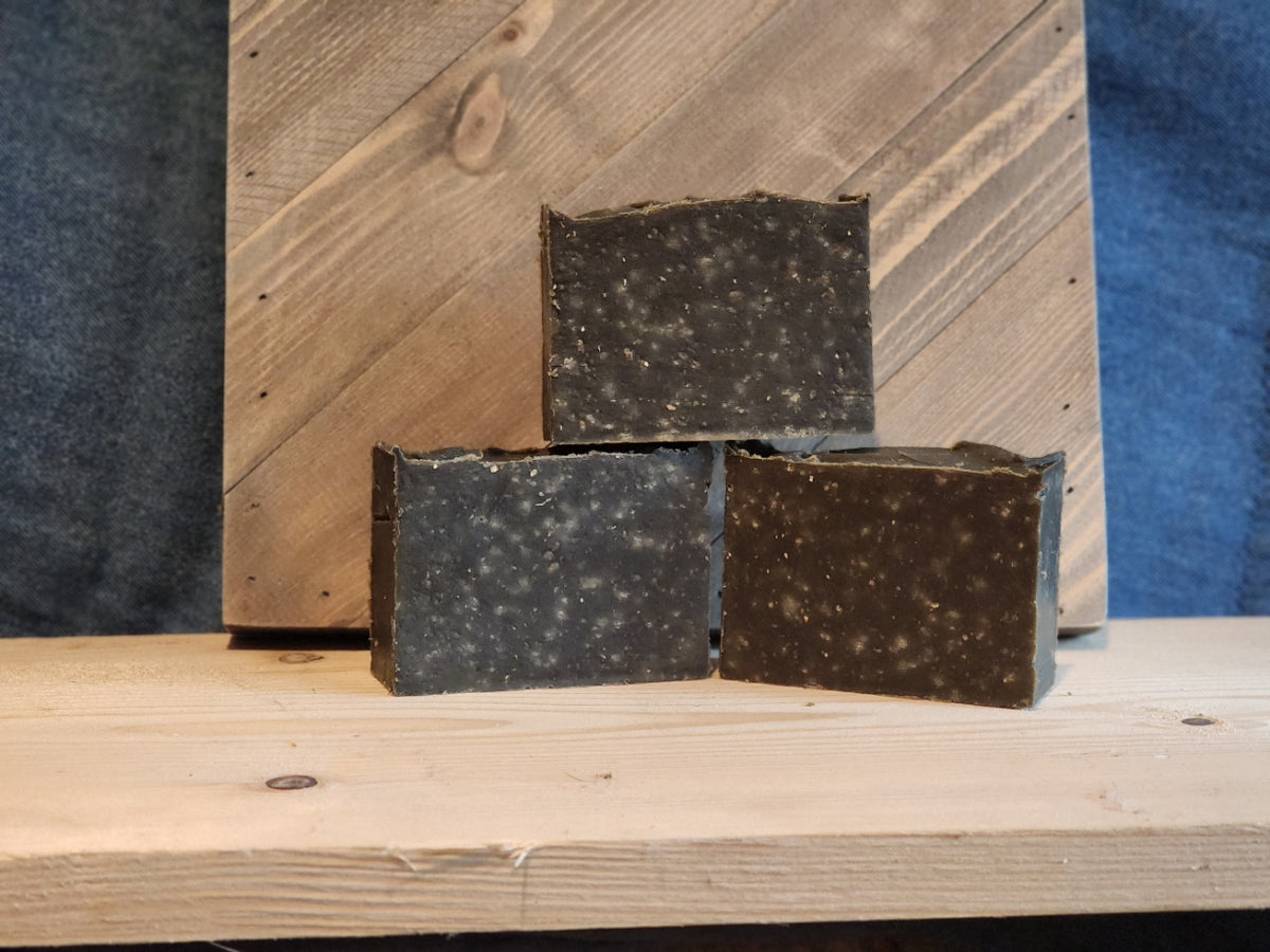 A stack of three bars of brown soap with whitish spots