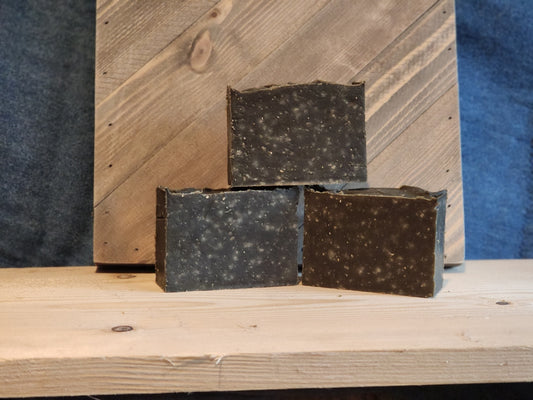 A stack of three bars of brown soap with whitish spots